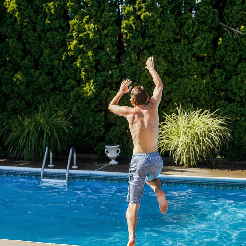 boy jumping into pool